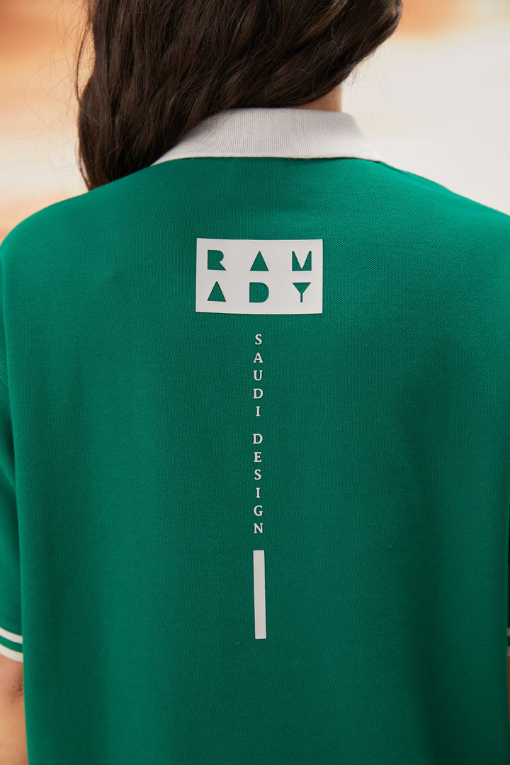 Female model wearing green polo tee with graphic chest print